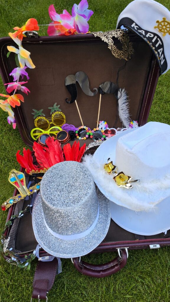 Valise d’accessoires pour photobooth : chapeaux, lunettes, moustaches et colliers de fleurs
