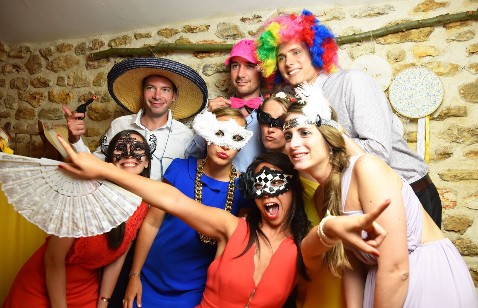 Un groupe d’invités avec masques et chapeaux pose pour la photo en soirée