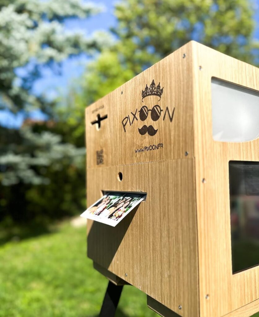 Location photobooth Pixoon, fabrication artisanale Photobooth Pixoon en bois de fabrication artisanale : logo gravé et tirage 10 x 15 qui sort de la fente d'impression