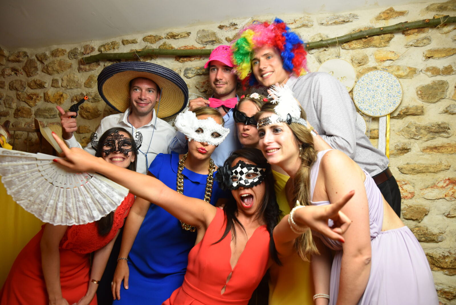 Un groupe d’invités avec masques et chapeaux pose pour une photo de groupe