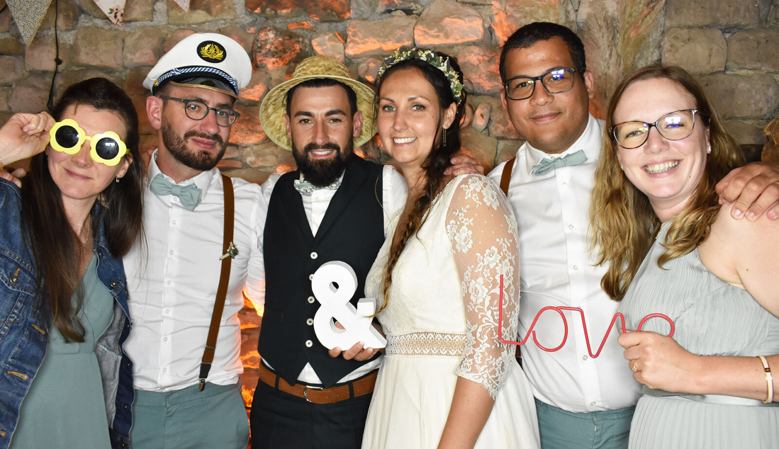 Quatre invités posent avec une pancarte « & Love »