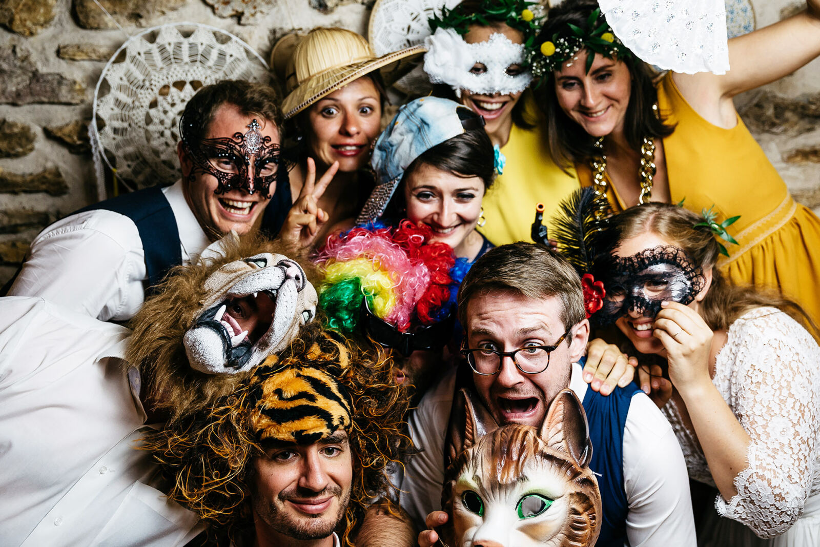 Un groupe d’invités masqués et costumés sourit devant l’objectif