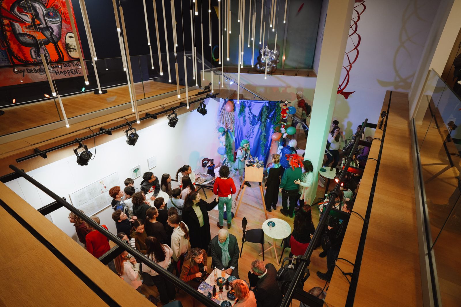 Soirée dans un musée vue d’en haut : le photobooth Pixoon devant un décor bleu, avec les invités rassemblés autour